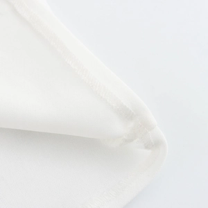 Close-up of white beaded camisole top featuring detailed stitching and fabric texture
