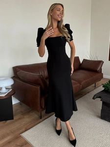 Detail of slim fit black puff sleeve midi dress with elegant square neckline and mermaid hem