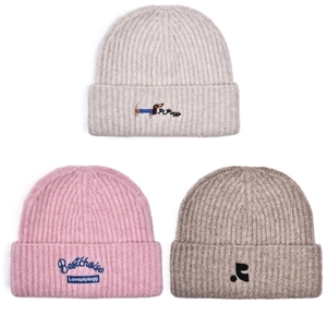 Detail of three knitted beanies with puppy embroidery in grey, pink and brown tones