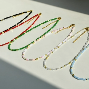 Close-up of six colorful crystal bead necklaces with gold spacers and lobster clasps