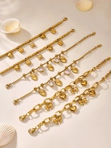Detail view of 18k gold plated stainless steel bracelets with bear and heart charms