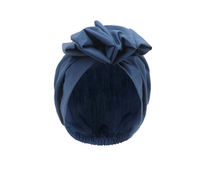 Detail of navy blue turban headwrap featuring elegant pleated fabric and large flower detail