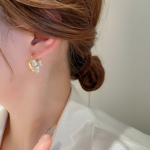 Elegant gold plated flower drop earrings with zircon and pearls on a female model