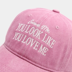 Détail macro d'une casquette vintage rose avec broderie blanche YOU LOOK LIKE en lettres