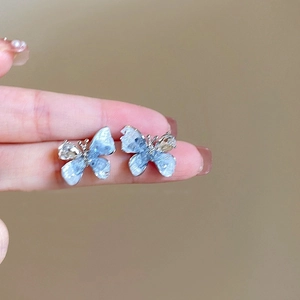 Vue détaillée des boucles d'oreilles papillon dégradé bleu avec cristaux