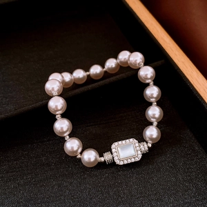 Detailed close-up of pearl bracelet with rectangular zircon pendant in black velvet box