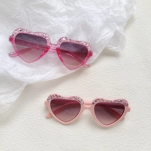 Sparkly heart-shaped kids sunglasses in pink and rose shades with glitter accents