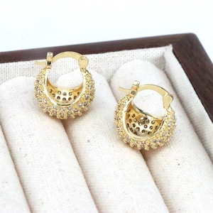 Boucles d'oreilles créoles dorées serties de zircons avec design boule évidée