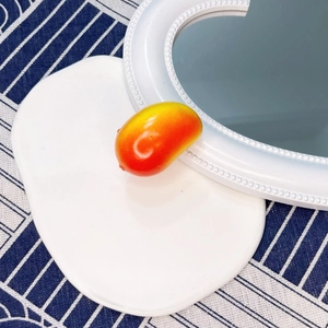 Detailed view of a realistic 3D mango hair clip with vibrant red-yellow gradient resin finish