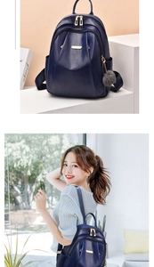 Detail of navy blue PU leather backpack with gold hardware and plush grey keychain accessory
