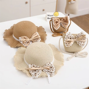 Detailed texture of straw sun hat and matching bag with floral lace bow accents