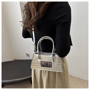 Silver crocodile texture handbag shown from back view on model for size perspective