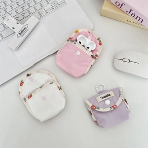 Close-up of floral fabric earphone case with snap button and layered storage design