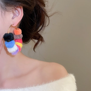 Close-up of vibrant multi-color faux fur pom-poms on a gold hoop earring for women