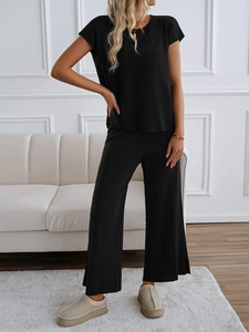 Detailansicht eines schwarzen zweiteiligen Stricksets mit ärmellosem Oberteil und weiter Hose
