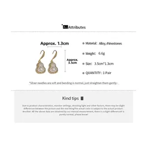 Detailed view of gourd earrings with pearls and crystals featuring silver ear pins