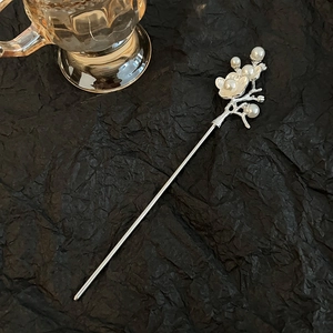 Close-up of silver flower hair pin with white pearls and elegant vintage design details