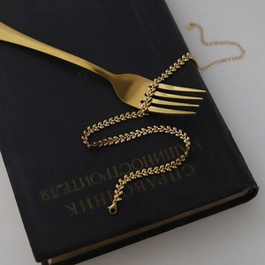 Macro detail of golden wheat leaf chain necklace with lobster clasp and extension