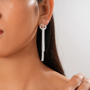 Close-up of silver long tassel earrings with square zircon stones on model's ear