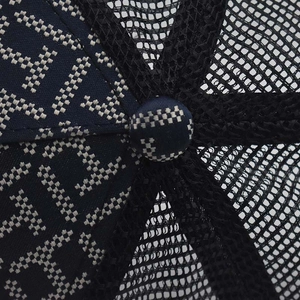 Macro detail of gradient baseball cap crown with H-pattern canvas and mesh fabric