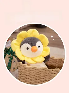 Close-up of plush penguin toy with sunflower collar in a cozy woven basket setting