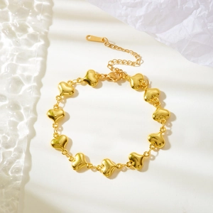 Detailed view of a golden heart-link bracelet with an adjustable lobster clasp