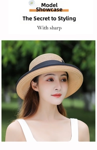 Detailed view of women's wide-brim straw sun hat with black ribbon and natural texture