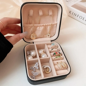 Elegant black portable jewelry box with velvet interior showing ring and earring storage