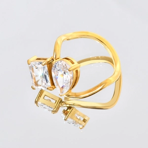 Macro detail of gold-plated wavy ring with pear and emerald cut cubic zirconia gems