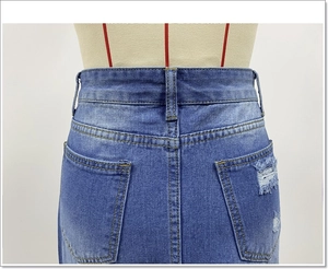 Vista dettagliata della gonna di jeans blu scuro con tasche consumate e cuciture a contrasto
