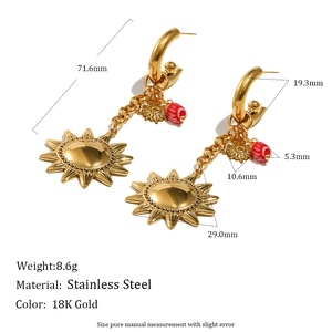 Detailed view of sun-shaped 18K gold-plated stainless steel earrings with red beads