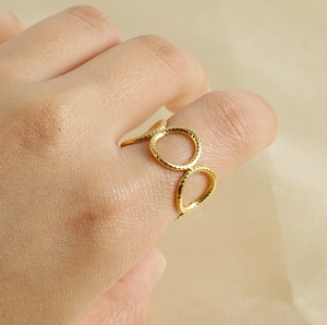 Detail of 18k gold plated geometric ring with hammered texture on model finger