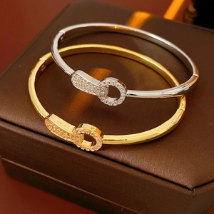 Close-up of gold and silver plated zircon bangles on a premium leather jewelry box