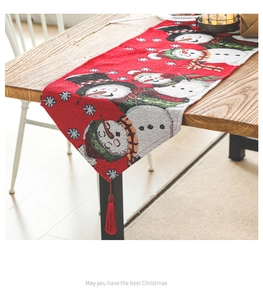 Close-up of Christmas table runner with snowman pattern and festive red tassels