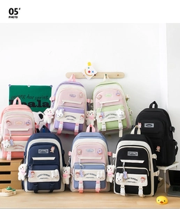 Various colored large school backpacks with cute bear charms in a stylish group display