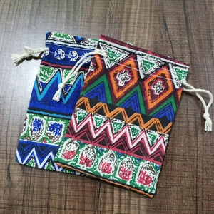 Detailed close-up of ethnic geometric print cotton drawstring bags on wood surface