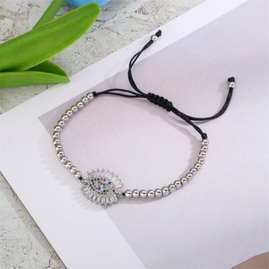 Détail d'un bracelet ajustable avec pendentif en éventail de zircons et cordon noir