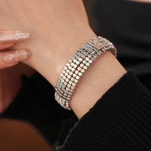 Détail d'un bracelet manchette argenté à cinq rangs de disques avec texture métallique