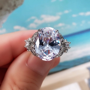 Detailed macro view of large oval zircon center stone and vintage engraved silver ring band