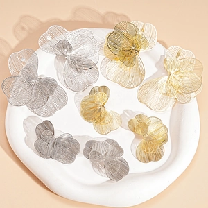 Minimalist metallic hollow flower earrings in gold and silver finish on white tray