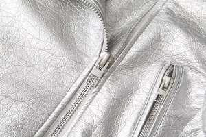 Detailed close-up of metallic silver faux leather texture and dual metal zipper structure