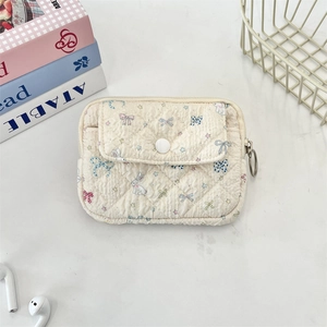 Detailed macro view of quilted cream fabric card holder with cute bunny and star patterns