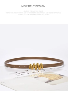 Detail of slim brown leather belt featuring a golden spiral wave buckle on a magazine