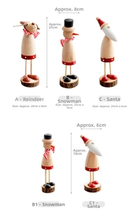 Detail view of wooden Christmas figurines including Santa, Reindeer and Snowman on bark base