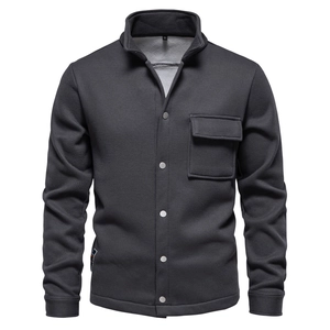 Detail of waffle knit fabric and metallic buttons on a dark grey stand-collar jacket