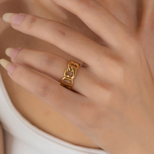 Close-up of a gold 18K plated stainless steel interlocking chain link ring on model