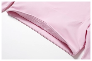 Detailed macro shot of reinforced flatlock stitching on pink athletic long sleeve shirt