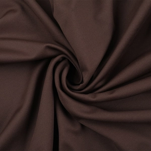 Gros plan sur le tissu jersey marron foncé montrant une texture douce et des plis drapés
