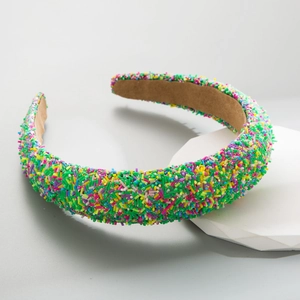 Detailed view of colorful rainbow sprinkle headband with brown velvet non-slip lining