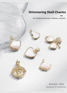 Close-up of 18k gold plated shell pendants including heart, clover and butterfly shapes